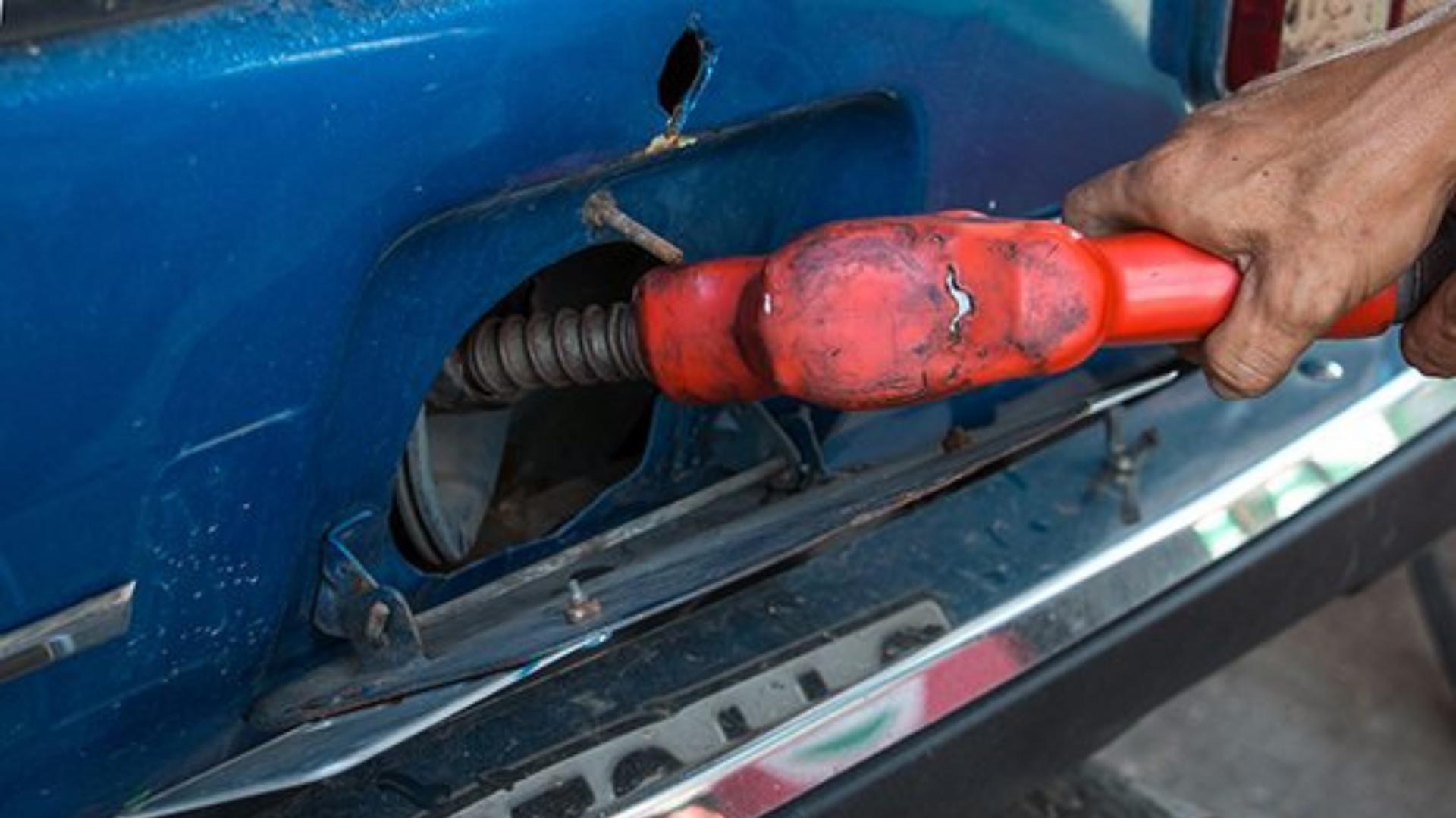 Una persona llena tanque de un auto en Cuba