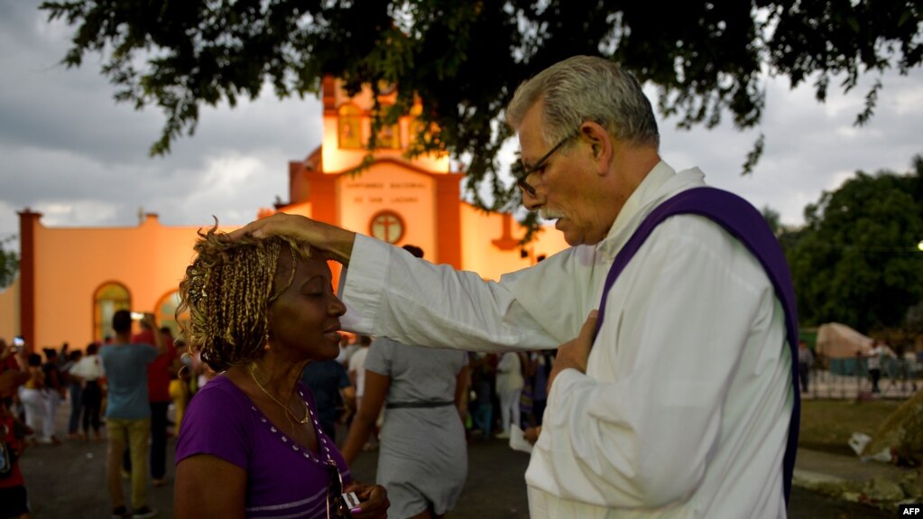 Un sacerdote bendice a un peregrino durante la procesión a El Rincón en adoración a San Lázaro, el 16 de diciembre de 2019 (Yamil Lage/AFP)