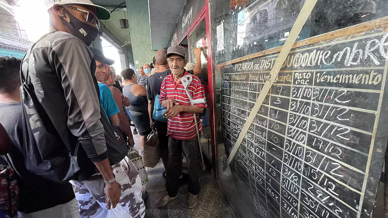 Cubanos esperan su turno en una cola para comprar los alimentos en La Habana